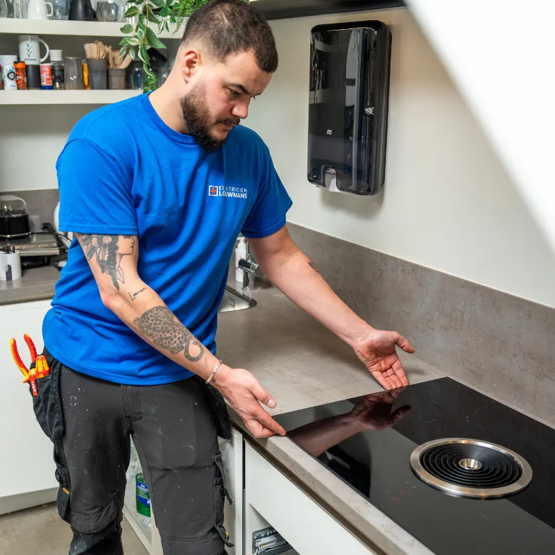 Elektricien bij een inductiekookplaat die wordt aangesloten
