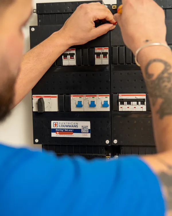 Elektricien plaatst een automaat in een nieuwe groepenkast
