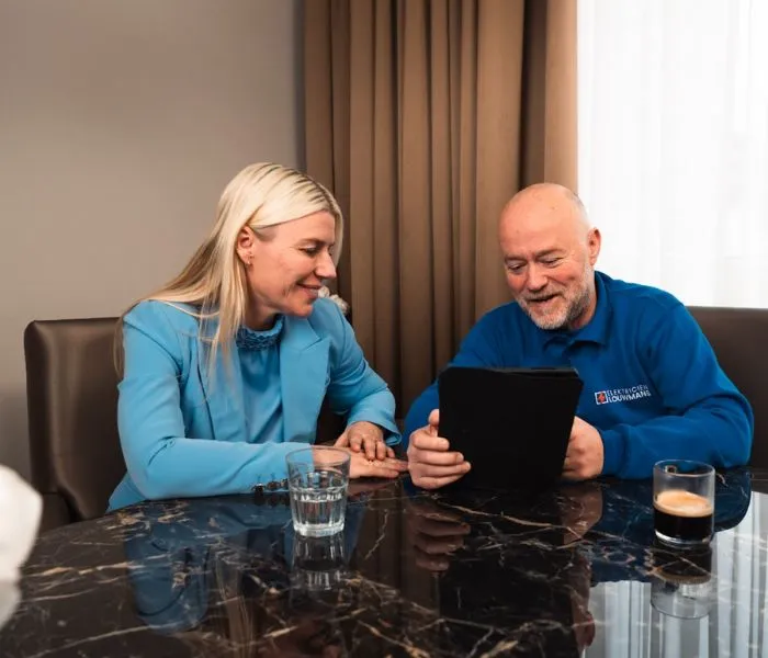 Elektricien bespreekt met een klant de mogelijkheden op een tablet
